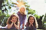 Portrait smiling grandmother with twin granddaughters in park