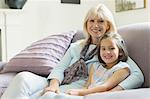 Portrait smiling grandmother and granddaughter on living room sofa