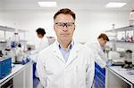 Scientist in laboratory, colleagues working in background