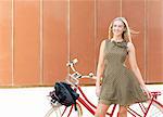 Young woman standing beside bicycle