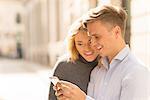 Couple sharing text message in street
