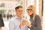 Couple sharing text message in street