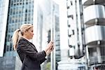 Businesswoman using digital tablet in street, London, UK
