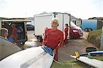 Group of surfers selecting surfboards, getting ready to surf