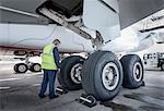 Engineer inspecting A380 aircraft at stand in airport