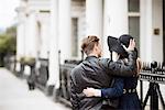 Rear view of romantic young couple strolling on street, London, England, UK