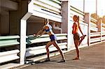 Two young female runners warming up in parking lot