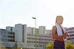 Young female runner checking smartwatch on urban rooftop