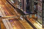 High angle view of city highway and Dubai metro rail station at night, downtown Dubai, United Arab Emirates