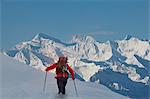 Rear view of climber moving up through deep snow, Swiss Alps, Canton Wallis, Switzerland