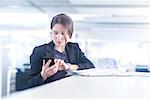 Businesswoman using smartphone in office