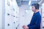 Side view of engineer in switchgear control room wearing headset