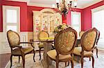 Glass dining table with high-back wooden chairs in dining room, cottage style home, Quebec, Canada