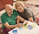 Male couple sitting on floor choosing color swatch