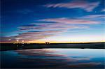 Reflection pool of dramatic evening sky and buildings illuminated by street light, Bonneville, Utah, USA