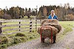 Woman pushing cart with hay