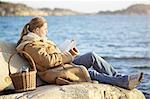 Woman reading book at sea