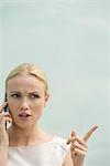 Woman making angry face while talking on cell phone