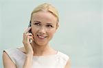Woman using cell phone, smiling