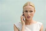 Woman receiving bad news on cell phone