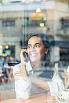 Woman talking on cell phone in coffee shop