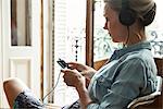 Woman listening to music playing on smartphone