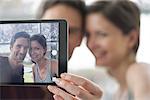 Couple using digital tablet to take a selfie