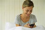 Woman sitting in bed texting