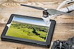 drone aerial photography concept - reviewing aerial picture of Colorado foothills near Fort Collins  on a digital tablet with a drone rotor and radio control transmitter,