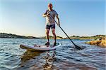 senior male paddler enjoying stand up paddling on a sunny summer day - Horsetooth Reservoir, Fort Collins, Colorado