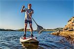 senior male paddler enjoying stand up paddling on a sunny summer day - Horsetooth Reservoir, Fort Collins, Colorado