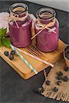 Fresh red fruits smoothie on vintage decorated  wooden table.