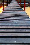 wooden footbridge over a river in sunrise light - path or journey metaphor