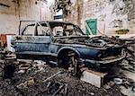 Old wrecked car inside of ruinous building