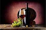 Delicious red wine with grape on wooden table