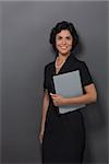 Businesswoman isolated over grey background. Young smiling caucasian lady in suit standing with files, documents and looking at the camera.