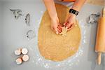 Closeup on woman making Halloween biscuits from rolled fresh dough in kitchen. Traditional autumn holiday. Upper view