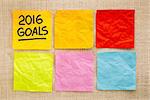 2016 New Year goals - handwriting on a sticky note against grained wood with blank notes