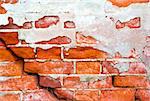 Brick cracked old weathered wall with an old plaster as a background