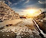 Way through ruins of egyptian pyramids and sun