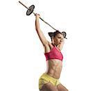 Muscular woman doing hard workout with barbell