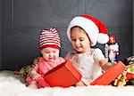 Cute little kids on rug opening a Christmas present