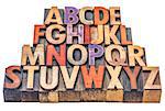 alphabet in vintage letterpress wood type stained by color inks,  isolated on white