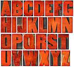 complete English alphabet set - a collage of 26 isolated vintage wood letterpress printing blocks, scratched and stained by red ink , gothic bold extended font