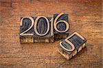 new year 2016 replacing the old year 2015 - letterpress wood type on a grunge wooden surface