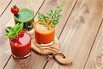 Fresh vegetable smoothie on wooden table. Tomato, cucumber, carrot. View with copy space
