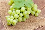 Bunch of white grapes with leaves over burlap napkin