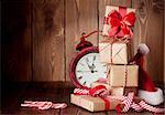 Christmas gift boxes, alarm clock and santa hat. View with copy space