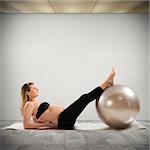Pregnant woman does fitness exercises with ball