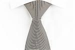 black and white spotted tie knotted Windsor, front view